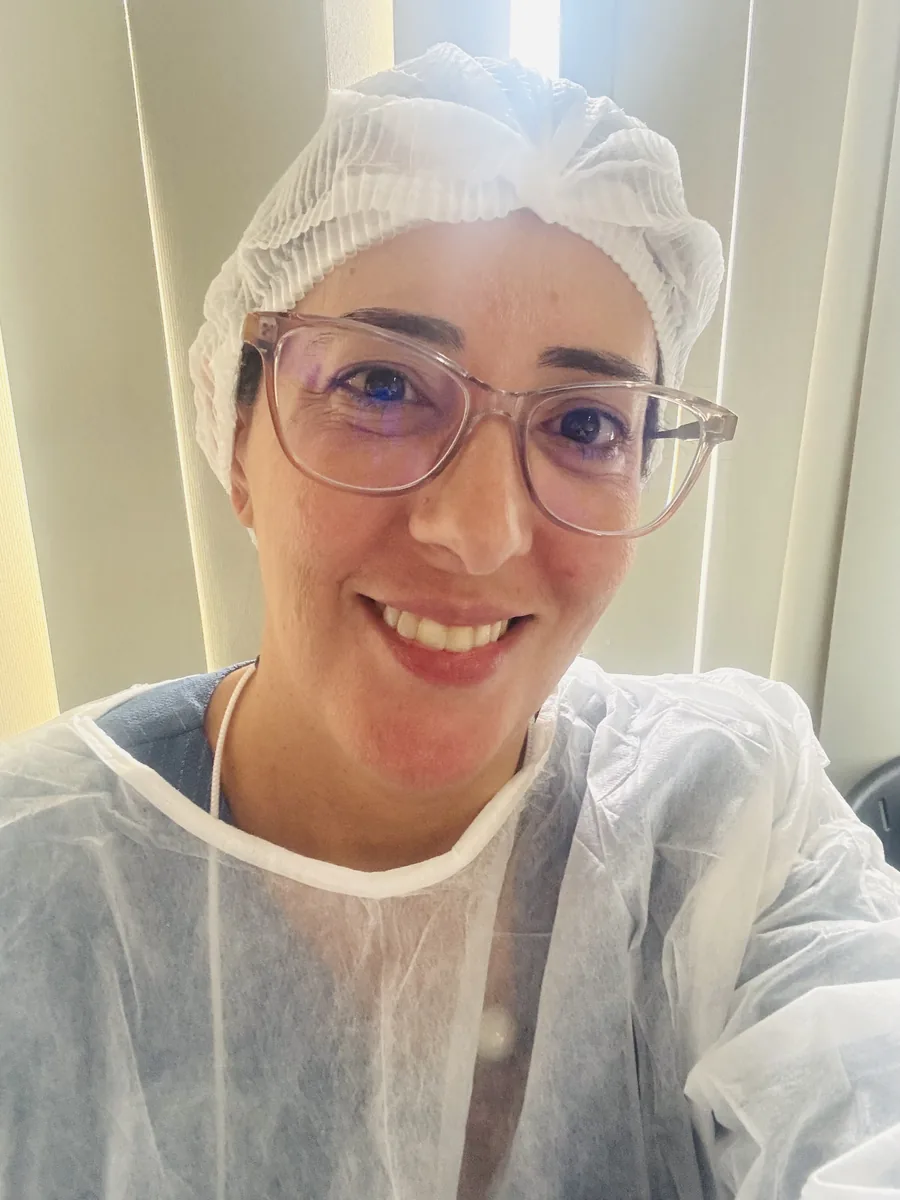 Taisa paramentada com touca e avental antes do atendimento